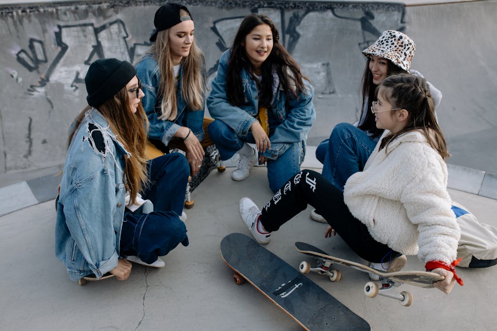 Group of diverse teenagers hanging out at a skatepark, chatting and enjoying leisure time.